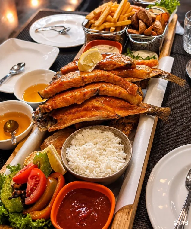 Фирменная жареная рыба Fish Fried на деревянной доске с гарниром